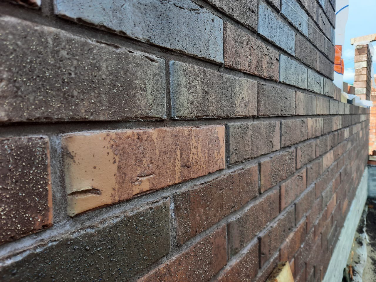 Строящийся дом из керамического блока облицованный кирпичом Гессен Вайн (Кирово-Чепецк). Для швов использована цветная кладочная смесь Perel черная 0065.