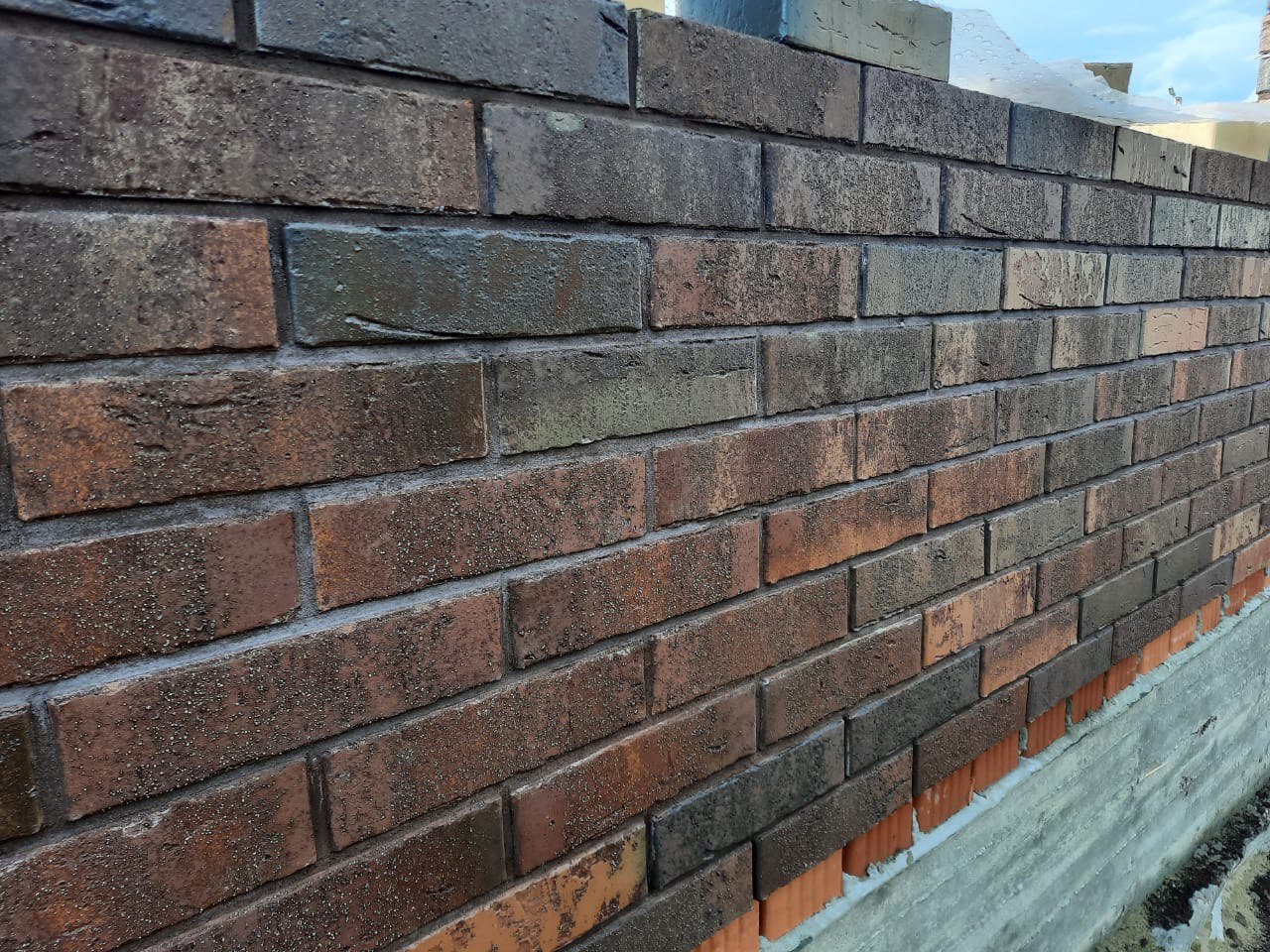 Строящийся дом из керамического блока облицованный кирпичом Гессен Вайн (Кирово-Чепецк). Для швов использована цветная кладочная смесь Perel черная 0065.