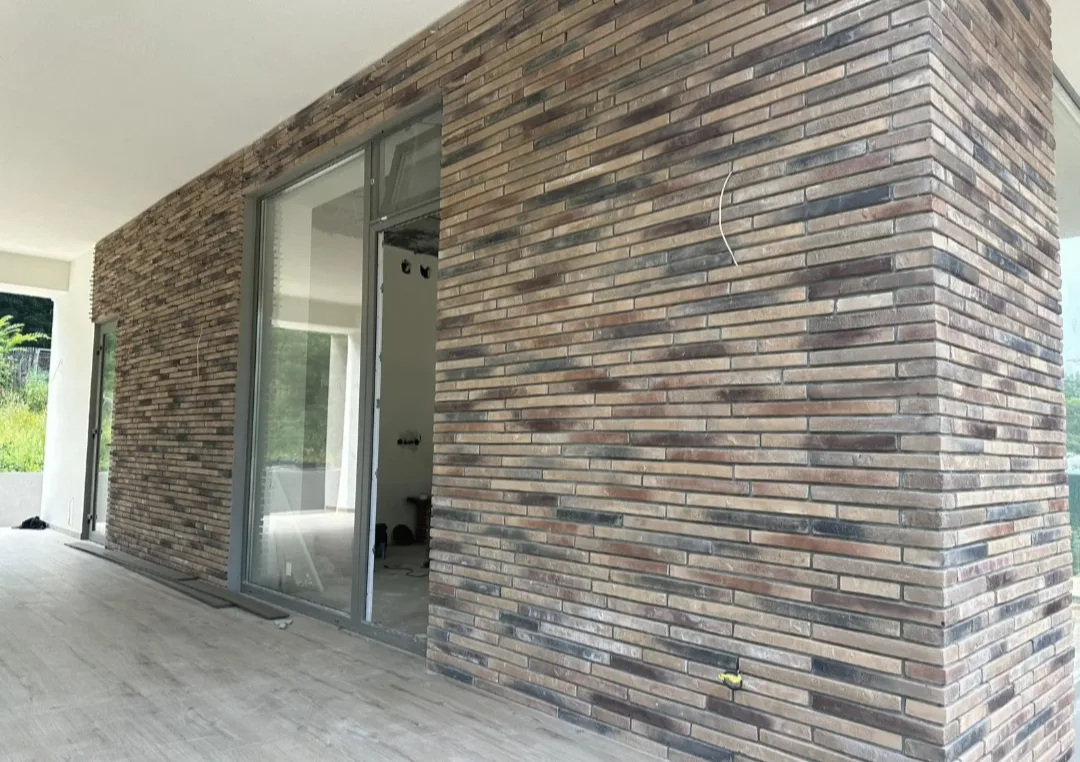 Дом облицованный декоративным кирпичом "Реген Брик" коричневый 690-40, 690-45, "Реген Брик" молочный 694-10, 694-15 (White Hills). Крепится к стене на клей White Hills "Экстра". Для швов использована затирка серая, белая (White Hills)